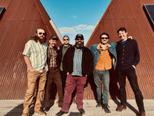 Load image into Gallery viewer, Group of six men posing together in front of a wooden building.
